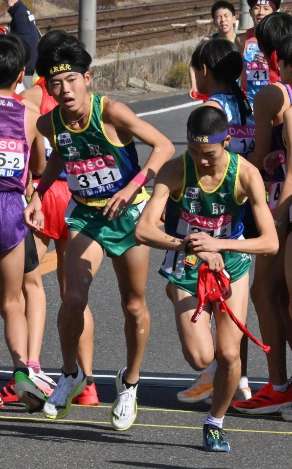 鳥取２区・土橋一輝（右）にたすきを渡す１区・本田桜二郎