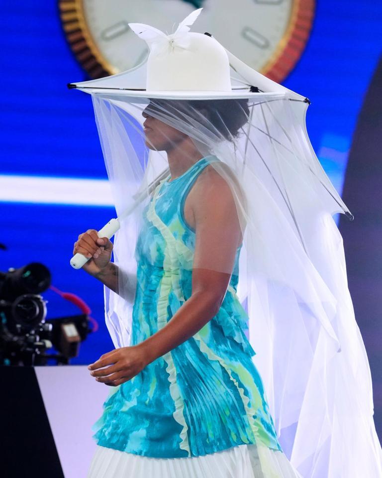 女子シングルス１回戦に、白で統一された傘、帽子姿で登場する大坂なおみ＝メルボルン（ＡＰ＝共同）