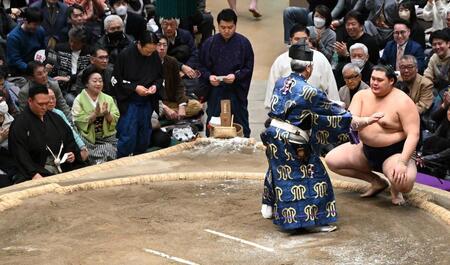霧島を下し、懸賞金を受け取る大の里（右）。左端は審判の二所ノ関親方