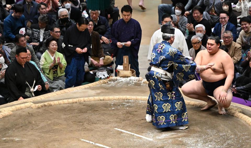 霧島を下し、懸賞金を受け取る大の里（右）。左端は審判の二所ノ関親方