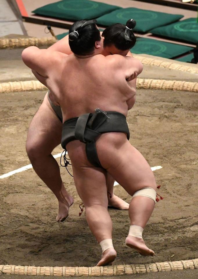 寄り切りで玄武丸（手前）を破った朝阪神（撮影・佐藤厚）