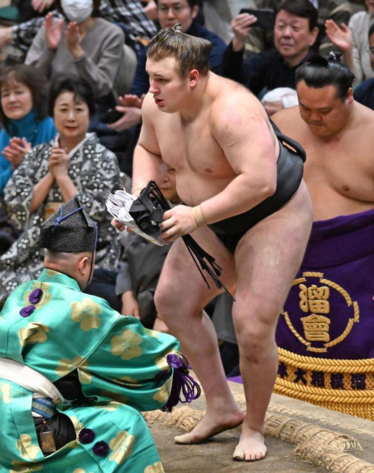 豊昇龍を上手投げで破り、懸賞金を受け取る安青錦