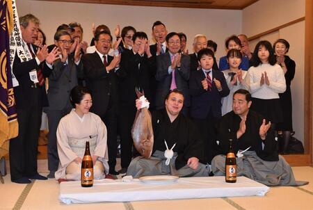 連覇を果たし鯛を手に会心の笑みを浮かべる安青錦（中央）。右は安治川親方、左は安治川部屋の女将・杉野森絵莉さん（撮影・開出牧）