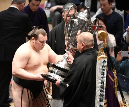 八角理事長（右）から賜杯を受け取る安青錦（撮影・佐藤厚）