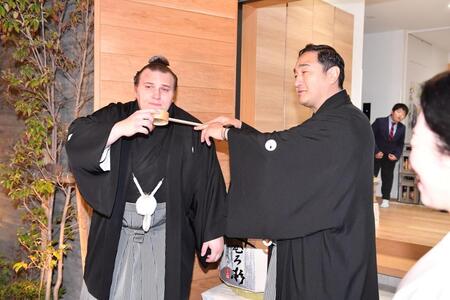 連覇を果たし安治川親方（右）から水付けを受ける安青錦（撮影・開出牧）