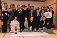 連覇を果たし鯛を手に会心の笑みを浮かべる安青錦（中央）。右は安治川親方、左は安治川部屋の女将・杉野森絵莉さん（撮影・開出牧）