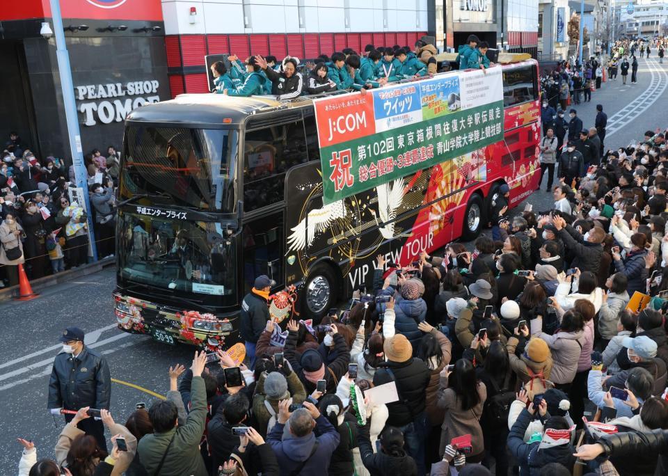 オープンカーでパレードする原晋監督（手前左）ら青学大の選手（撮影・西岡正）