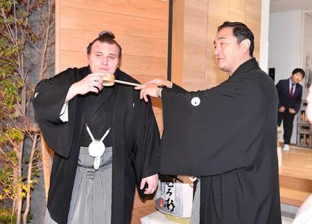 　連覇を果たし安治川親方（右）から水付けを受ける安青錦（撮影・開出牧）