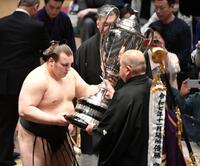 　八角理事長（右）から賜杯を受け取る安青錦（撮影・佐藤厚）