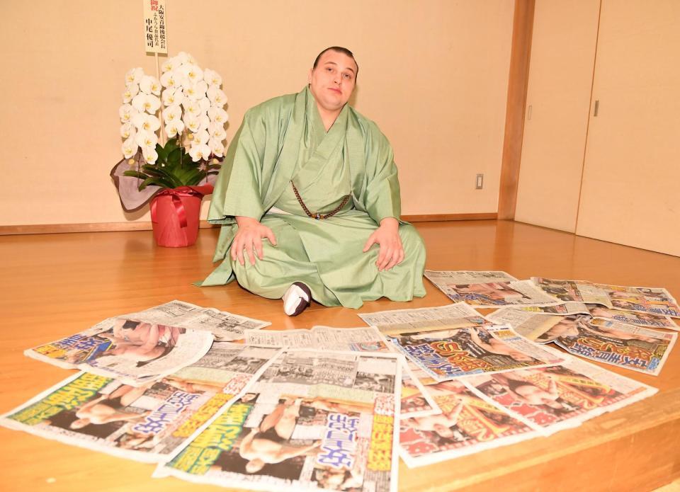 連覇を報じるスポーツ新聞各紙を並べポーズをとる安青錦（撮影・開出牧）