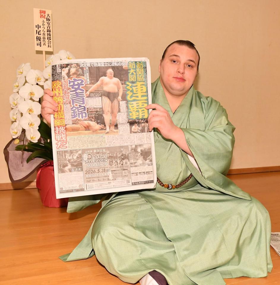 連覇を報じるデイリースポーツを手にポーズをとる安青錦（撮影・開出牧）