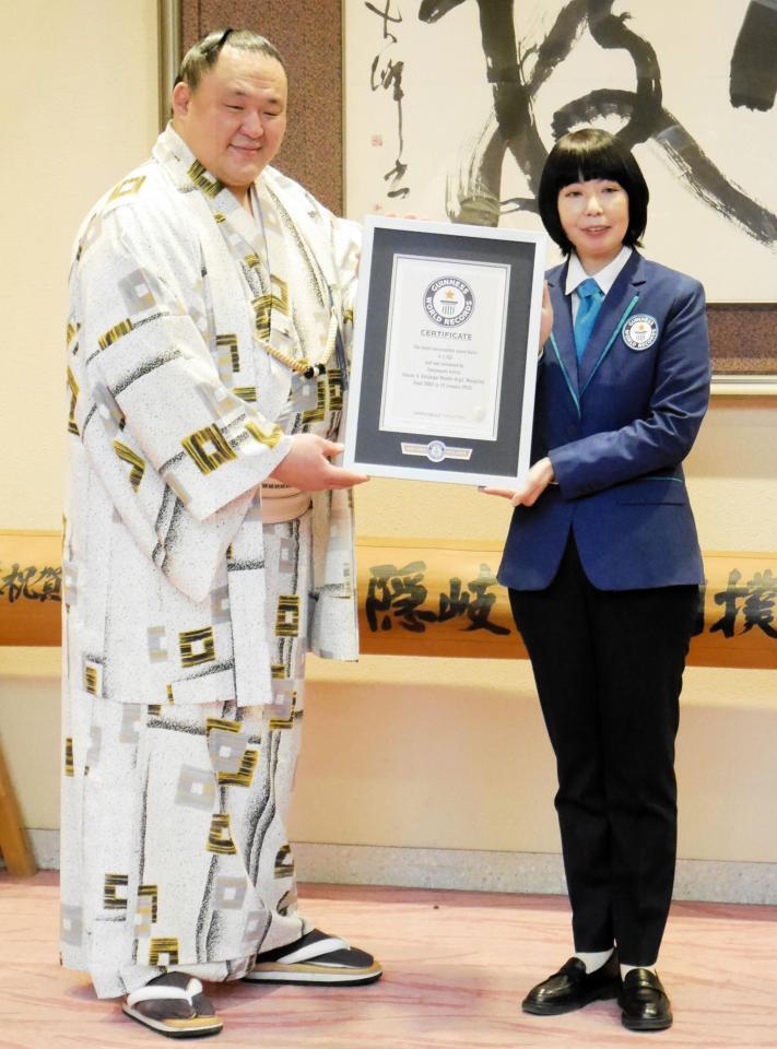 ギネス世界記録公式認定員の石川佳織さんからギネス世界記録認定証を受け取る玉鷲