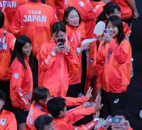 パリ五輪の閉会式で記念撮影する仲間を笑顔で見つめる田中希実（左）と一山麻緒（中央右）＝２０２４年８月