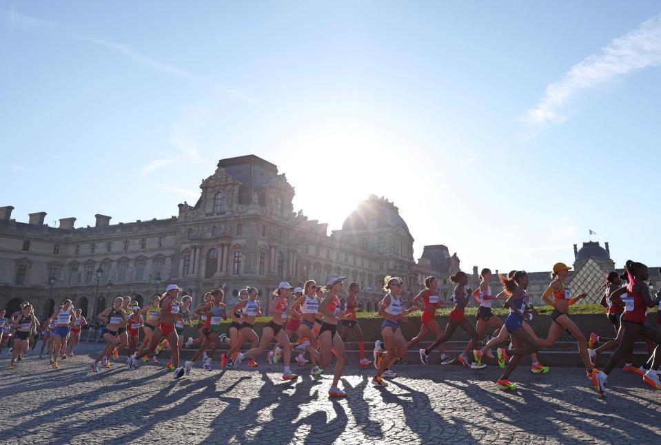 パリ五輪でルーブル美術館前を通過する一山麻緒（中央オレンジユニホーム）と鈴木優花＝２０２４年８月