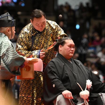 伊勢ケ浜親方（右）のまげにハサミを入れる白鵬氏（撮影・開出牧）