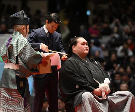 伊勢ケ浜親方（右）のまげにハサミを入れる亀田和毅（撮影・開出牧）