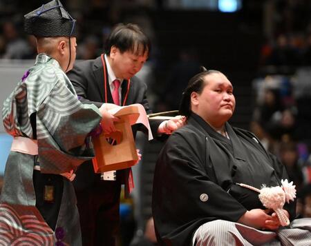 伊勢ケ浜親方（右）のまげにハサミを入れる大橋秀行会長（撮影・開出牧）