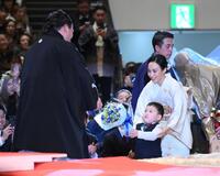 断髪式で家族から花束を受け取る伊勢ケ浜親方（左）。右からドルジハンド夫人、長男の照務甚（テムジン）くん（撮影・開出牧）