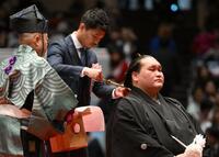 伊勢ケ浜親方（右）のまげにハサミを入れる中谷潤人（撮影・開出牧）