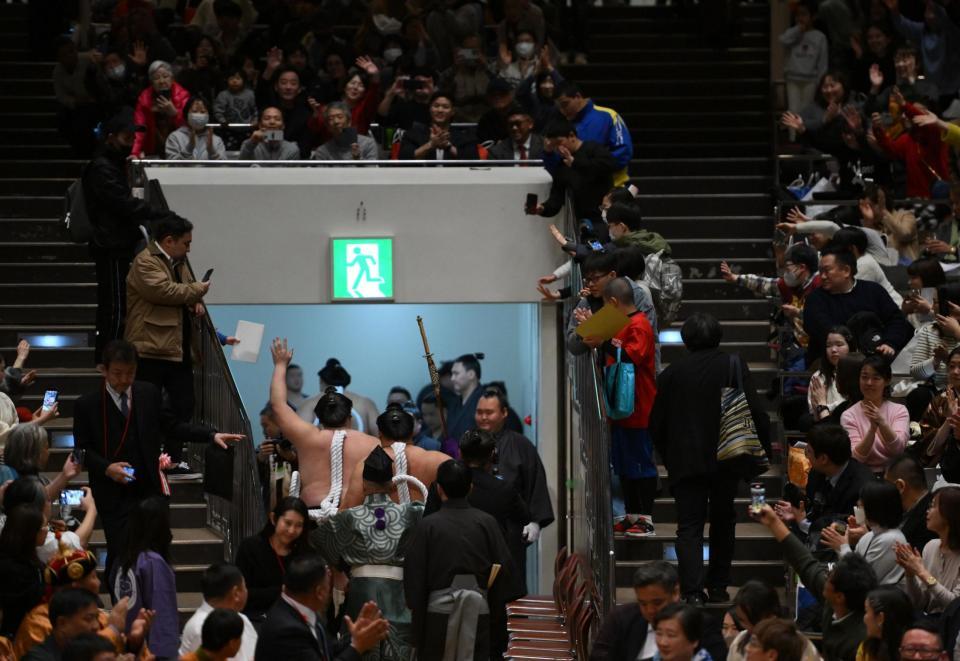 最後の土俵入りを終え観客に手を振り引き揚げる照ノ富士（左下）＝撮影・開出牧