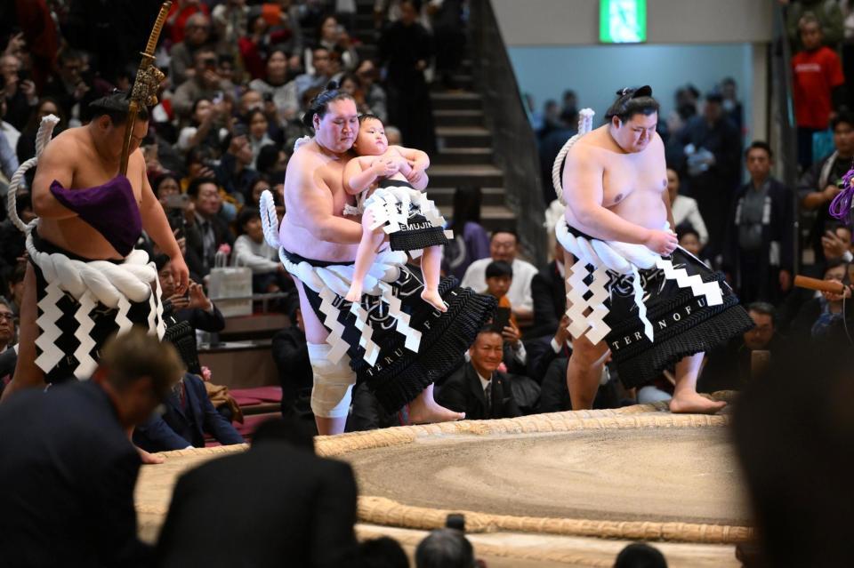 長男・照務甚（テムジン）くんを抱っこして最後の土俵入りを行う照ノ富士（左中央）。左は太刀持ち・豊昇龍、右は露払い・大の里（撮影・開出牧）