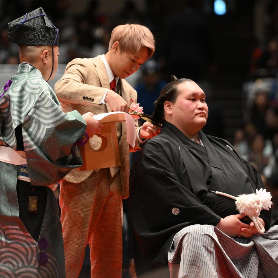 伊勢ケ浜親方（右）のまげにハサミを入れる武尊（撮影・開出牧）