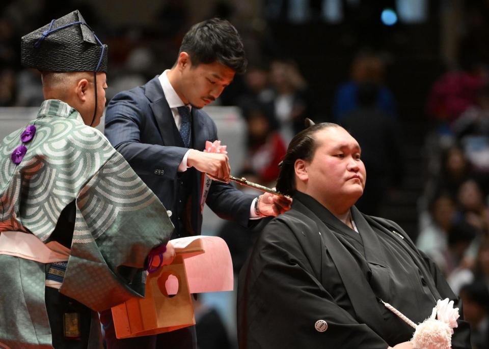 伊勢ケ浜親方（右）のまげにハサミを入れる中谷潤人（撮影・開出牧）