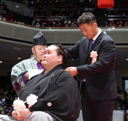 元横綱照ノ富士の伊勢ケ浜親方（左）に、はさみを入れる中田翔さん
