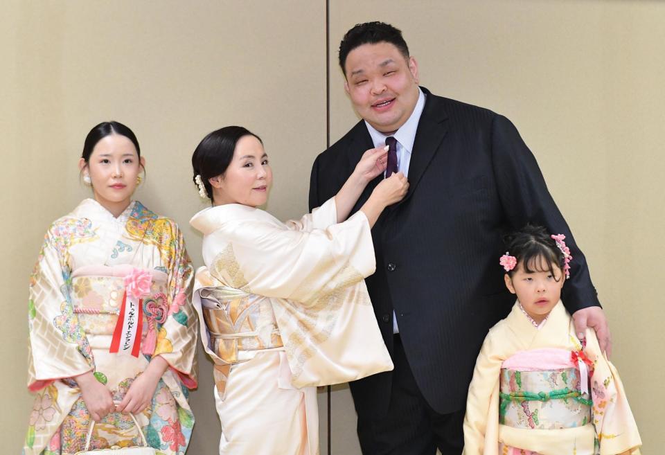 　整髪を終えスーツ姿で家族と記念撮影する水戸龍。左から長女・エンフジンさん、ダワスレン夫人、次女・イスンエルデンちゃん（撮影・開出牧）