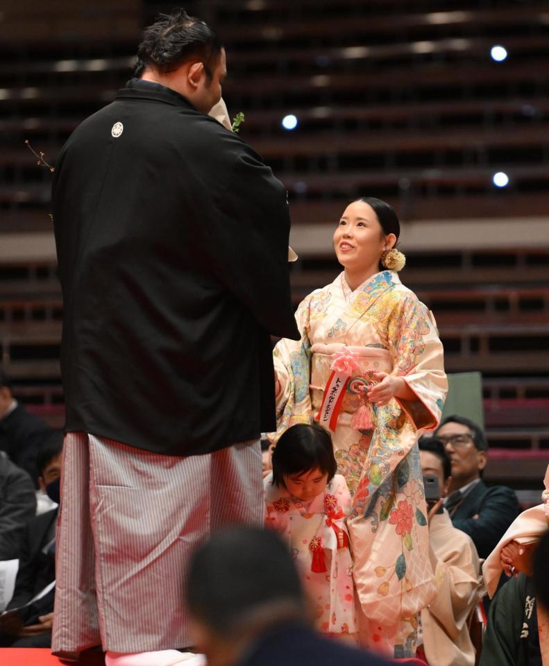 　長女・エンフジンさん（右）から花束（右）を受け取る水戸龍。中央下は三女・ツゥレンネルデンちゃん（撮影・開出牧）