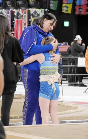 女子小学６年生の部軽量級の準決勝で敗れ、コーチの胸に顔をうずめて号泣するソフィア・イソイアンさん