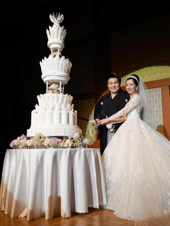 ウェディングケーキに入刀する欧勝馬と夫人