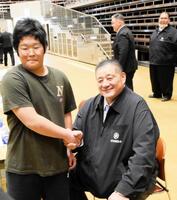 合格を言い渡され佐渡ケ嶽親方と握手を交わす芳野竜汰