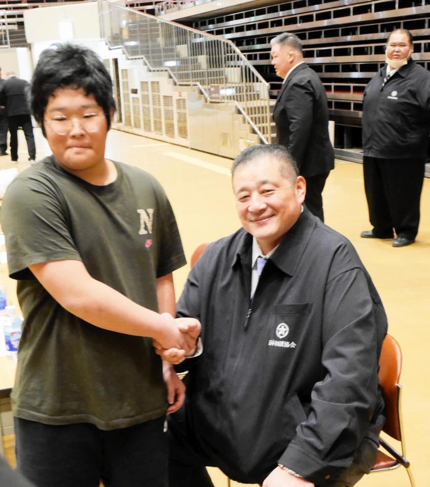 合格を言い渡され佐渡ケ嶽親方と握手を交わす芳野竜汰