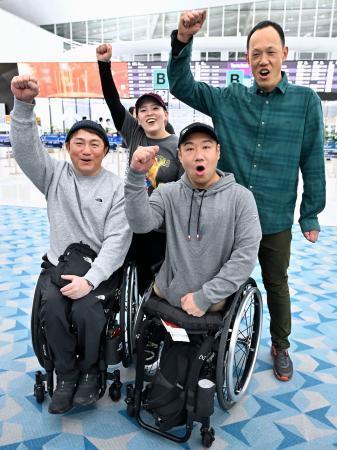 　出発を前にポーズをとる、ミラノ・コルティナ冬季パラリンピックに出場するアルペンスキーの森井大輝（前列左）、鈴木猛史（同右）ら＝２１日午後、羽田空港