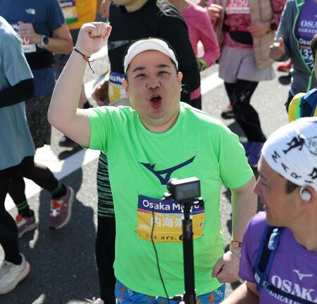 カメラに向かって拳を突き上げるミルクボーイ・内海崇＝大阪府庁前（撮影・中田匡峻）