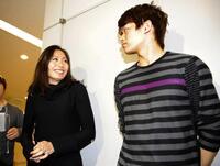 帰国し、囲み取材で笑顔を見せる安藤美姫（左）右は小塚崇彦＝０９年１０月