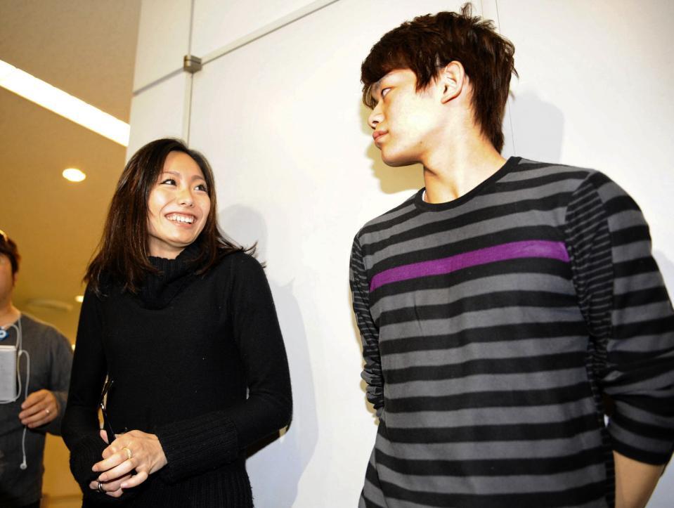 帰国し、囲み取材で笑顔を見せる安藤美姫（左）右は小塚崇彦＝０９年１０月