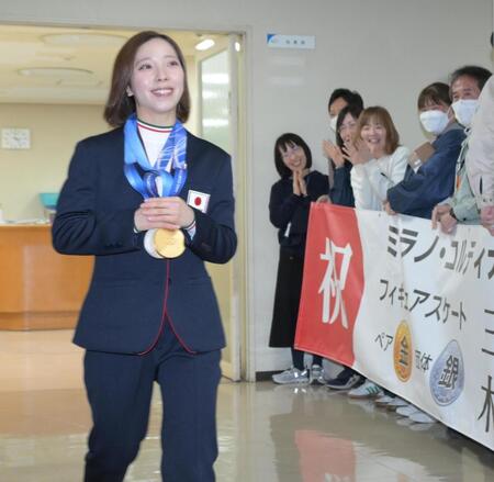 お祝いの横断幕を持つ職員に出迎えられる三浦璃来（撮影・金居みつよし）