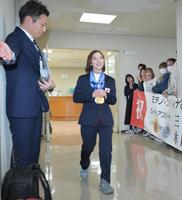 お祝いの横断幕を持つ職員に出迎えられる三浦璃来（撮影・金居みつよし）