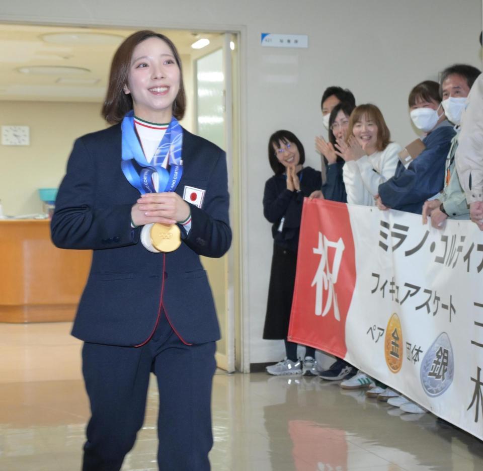 お祝いの横断幕を持つ職員に出迎えられる三浦璃来（撮影・金居みつよし）