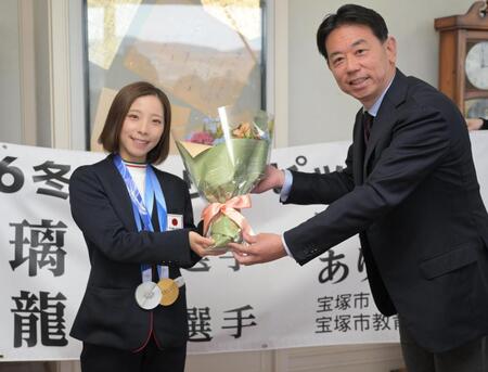 宝塚市の森市長（右）から祝福の花束を手渡される三浦璃来＝２日