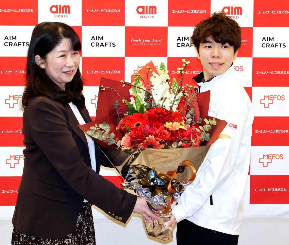 　所属先の社員交流会で花束を受け取る佐藤駿（右）