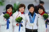 女子団体追い抜きで３人の銀メダルを掛けてもらい（左から）田畑、小平、穂積（右）と記念写真に納まる高木美帆＝２０１０年２月　