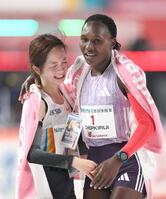 ゴール後、健闘をたたえ合う２位の佐藤早也伽（左）と優勝したシェイラ・チェプキルイ