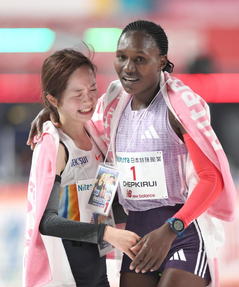 ゴール後、健闘をたたえ合う２位の佐藤早也伽（左）と優勝したシェイラ・チェプキルイ