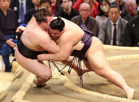 安青錦（左）を寄り倒しで破る義ノ富士（撮影・中田匡峻）