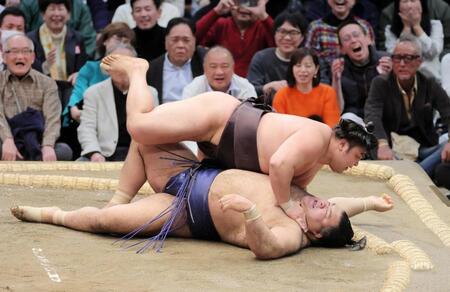 霧島（上）がすくい投げで高安を破る