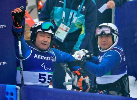 　男子回転座位で銅メダルを獲得し、手を振る鈴木猛史。右は森井大輝＝コルティナダンペッツォ（共同）