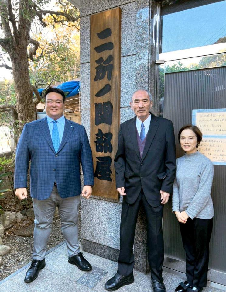 横綱稀勢の里の二所ノ関親方（左）と旧二所ノ関部屋の前に立つ元大関若嶋津の荒磯親方。６５歳となり日本相撲協会の定年を迎えた。右はみづえ夫人＝２０２１年１２月